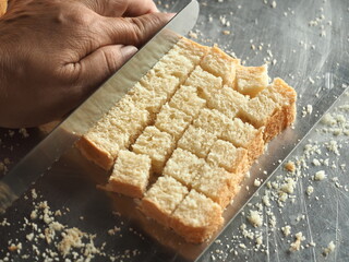 slicing white bread into cubes for making croutons - obrazy, fototapety, plakaty
