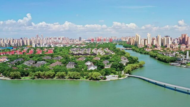 Aerial footage of city skyline and modern residential buildings with river natural scenery in Suzhou, China.