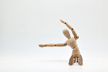 a wooden mannequin doing exercises on white background. warm up exercise