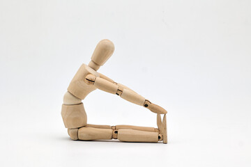 a wooden mannequin doing exercises on white background. warm up exercise - 518261773