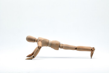 a wooden mannequin doing exercises on white background. Push-up exercise.