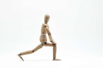 a wooden mannequin doing exercises on white background. warm up exercise