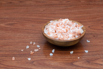 Obraz na płótnie Canvas Himalayan pink salt in a wooden cup on wooden background