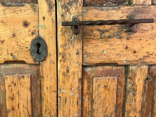 wooden door with rusty key lock hole and handle