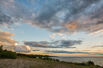 Naklejka na ściany i meble landscape photo of the sea with the road against the background of the sunset sky