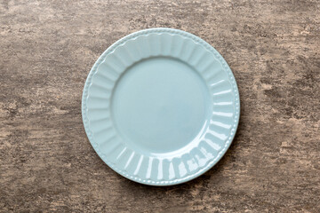 Top view of empty grey plate on cement background. Empty space for your design