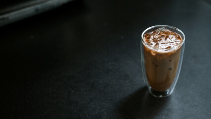 Ice coffee on a table with cream being poured into it showing the texture