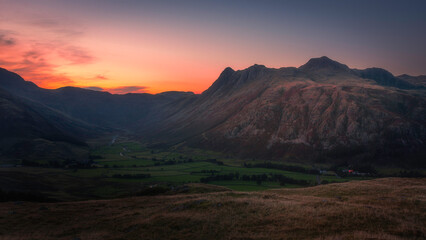 Sunset over Langdale Pikes in Lake District, UK. Beautiful evening landscape scene with the colourful sky over mountains.