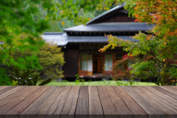 Wooden table top with blurred garden and japan house.   