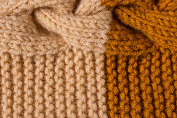 Knitted texture background. Hand-knitted wool. Macrophotography of a thread drawing. Orange beige texture of sweaters, pullovers, cardigans. Abstract natural background. Comfort autumn warmth concept