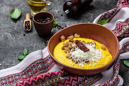 Traditional Ukrainian banosh with corn porridge cheese and lard on a dark background. Ukrainian cuisine. banner, menu, recipe place for text, top view