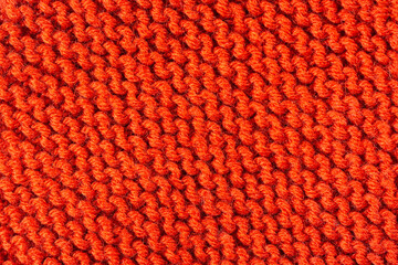 Knitted texture background. Hand-knitted wool. Macrophotography of a thread drawing. Orange bright...