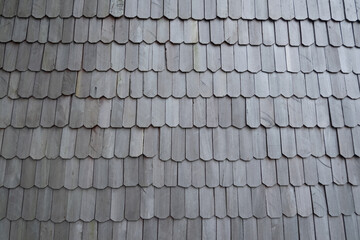 exterior details of the roof of a house made of ironwood, dark gray background texture