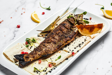 Baked trout fish with salt, lemon. Grilled trout. Fish dish fried fish fillet with vegetables. Ketogenic, keto or paleo diet lunch, Healthy food trend. Top view