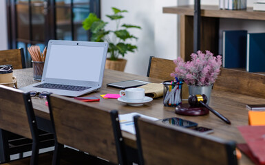 Blank gray screen laptop notebook computer with copy space for advertising placed on old wooden table workstation desk in vintage style cafe with nobody full of lawyer office stationery and equipment