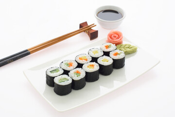Maki Sushi. Delicious sushi rolls on white plate with chopsticks and wasabi