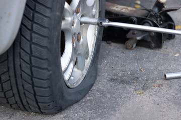 The car had a flat tire on the asphalt. Summer day .