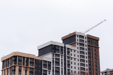 Tall residential buildings under construction in the far away. Several cranes on the background