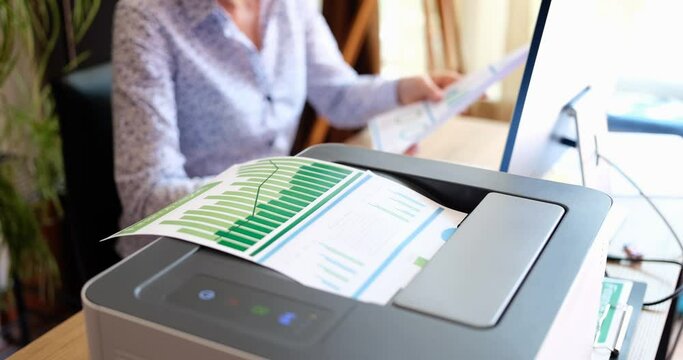 A woman in the office prints a report on a printer