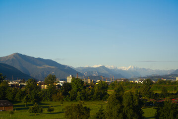 Skyline of City of Baar and Zug with Swiss Alps in the background on a sunny summer day. Photo taken June 25th, 2022, Zug, Switzerland.