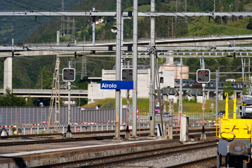 Railway station Airolo, Canton Ticino, with railway tracks and yellow construction train on a sunny...