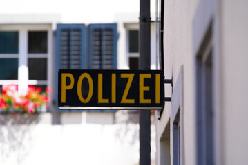 Obraz premium Close-up of black and yellow police (German Polizei) sign at police station at City of Altdorf, Canton Uri, on a sunny summer day. Photo taken June 25th, 2022, Altdorf, Switzerland.