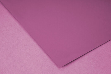 Plain pink paper sheet lying on textured Background like an open book from top angle
