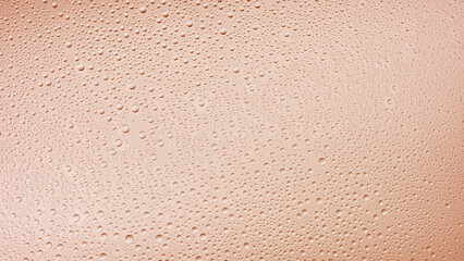 Fototapeta premium Medium size water drops on the wet glass surface on beige background | Background for skin care moisturizing products