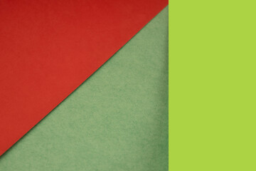 Textured and plain green red yellow sheet papers forming two triangles and vertical blank rectangle for creative cover designing