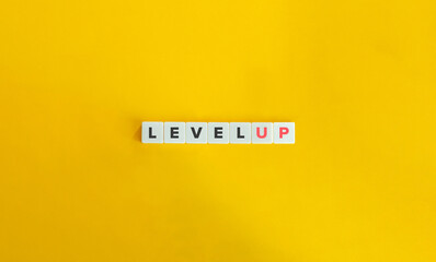 Level Up Banner and Phrasal Verb. Letter Tiles on Yellow Background. Minimal Aesthetics.