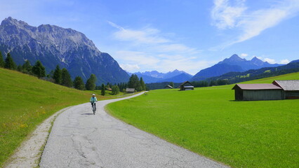 Radlerin unterwegs auf den Buckelwiesen von Mittenwald nach Krün