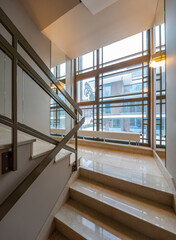 Modern interior of entrance in apartment building. Staircase. Window.