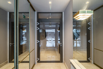 Modern interior of entrance in apartment building. Glass door.