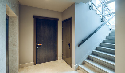 Modern interior of entrance in residential building. Doors, staircase