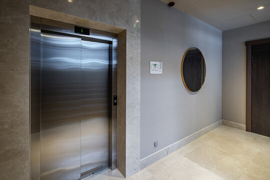 Modern grey interior of entrance in apartment building. Elevator.