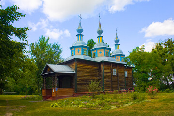 Fototapeta na wymiar Old wooden church (now Museum of the Ukrainian Rushnik) in in Open-air Museum of Folk Architecture and Life of the Middle Dnieper in Pereyaslav-Khmelnitsky, Ukraine