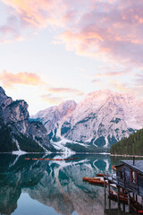 Stunning sunrise on Lake Braies (Lago di Braies) with some wooden boats and beautiful mountains reflecting in the water. Lago di Braies is an alpine lake in the Dolomites, Italy.