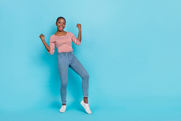 Full body portrait of excited overjoyed person raise fists triumph luck empty space isolated on blue color background