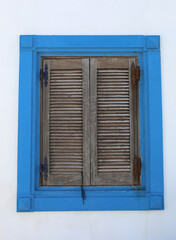 Window of the old Greek Home with Brown Window shutters and Blue Frames in Urla,Turkey