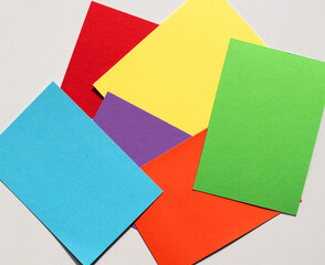 random arranged colored paper with texture on a light grey background