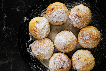 vanilla muffins with powdered sugar on a plate close-up. sweet pastries top view