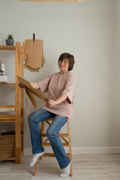 Mature female seamstress examining templates