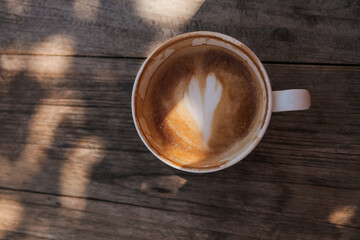 Cup of cappuccino coffee with heart shape. 
