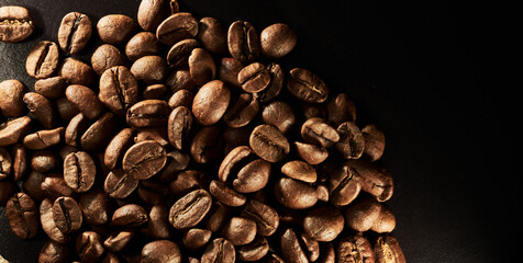Roasted coffee beans isolated close up on black background, clipping path