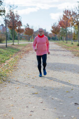 Fototapeta premium Senior retired man runs and performs exercise