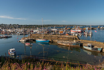 Fototapeta na wymiar Newlyn Harbour, Penzance, Cornwall, England, UK. 2022. Commercial fishing boats and leisure craft in port at Newlyn Harbour, viewed from. the old harbour.