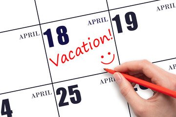 A hand writing a VACATION text and drawing a smiling face on a calendar date 18 April. Vacation...