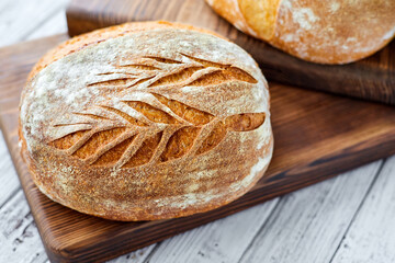 Freshly baked homemade wheat bread on a wooden background. Close-up, selective focus