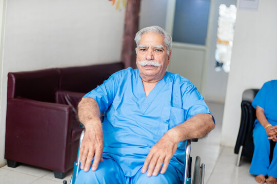 Elderly indian male paralyzed patient sitting on wheel chair at hospital ward, old people healthcare and medical concept.
