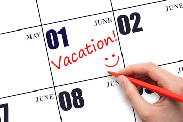 A hand writing a VACATION text and drawing a smiling face on a calendar date 1 June. Vacation...
